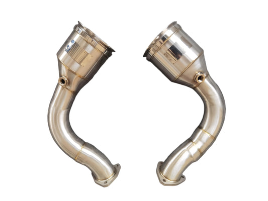 A pair of stainless steel catless downpipe exhaust components for a Lamborghini Urus, showing a metallic finish with no visible branding or model information.