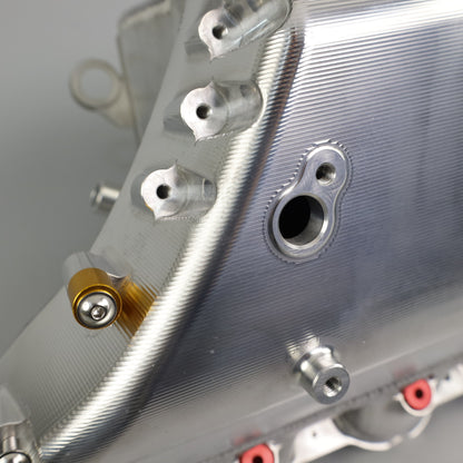 Close-up of a metallic engine cover with bolts on a gray background