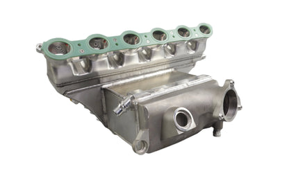 Metal engine manifold with gasket on a gray background
