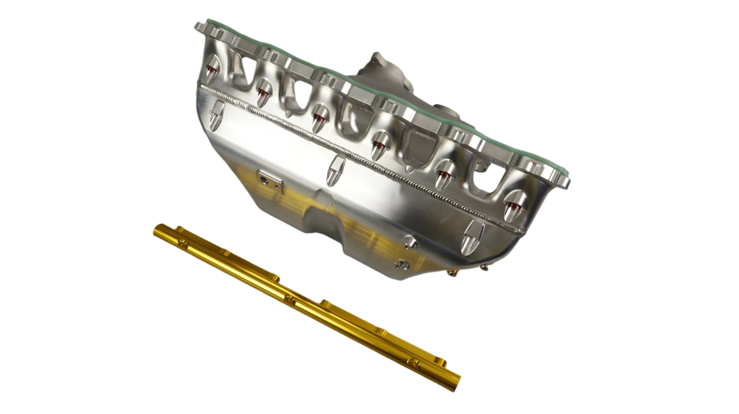 Metallic engine component with gold-colored tool on a gray background
